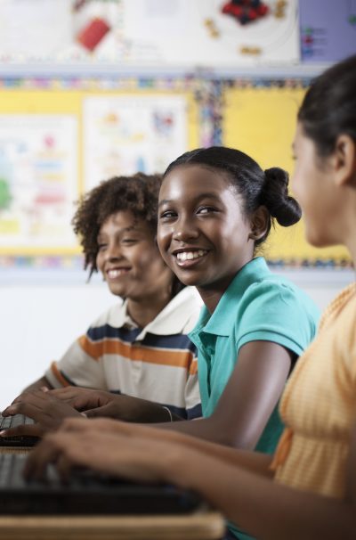 Three students sitting in class, a girl and two boys.